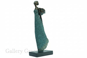 Bronze sculpture of a woman with a flowing dress on a white background