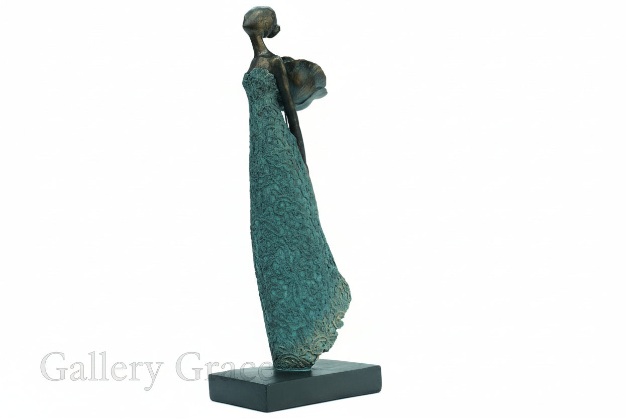 Bronze sculpture of a woman with a flowing dress on a white background