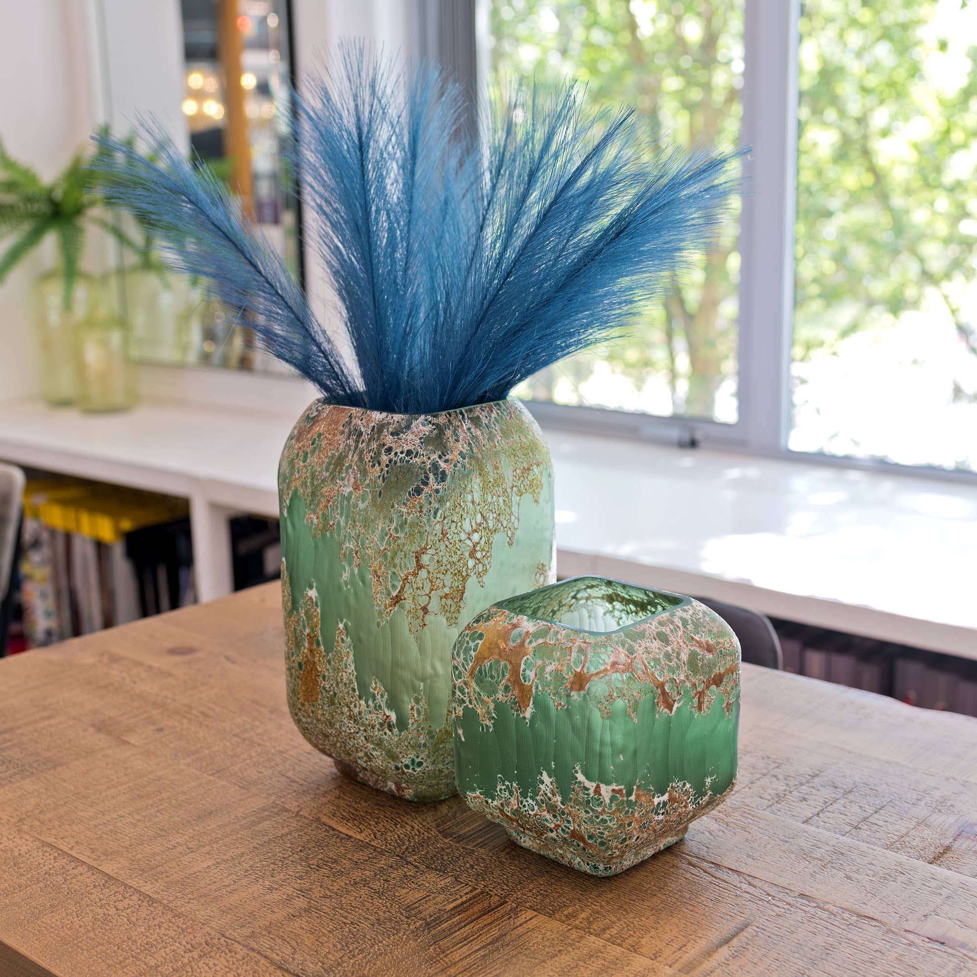 Green ceramic vase with marbled pattern on a green background