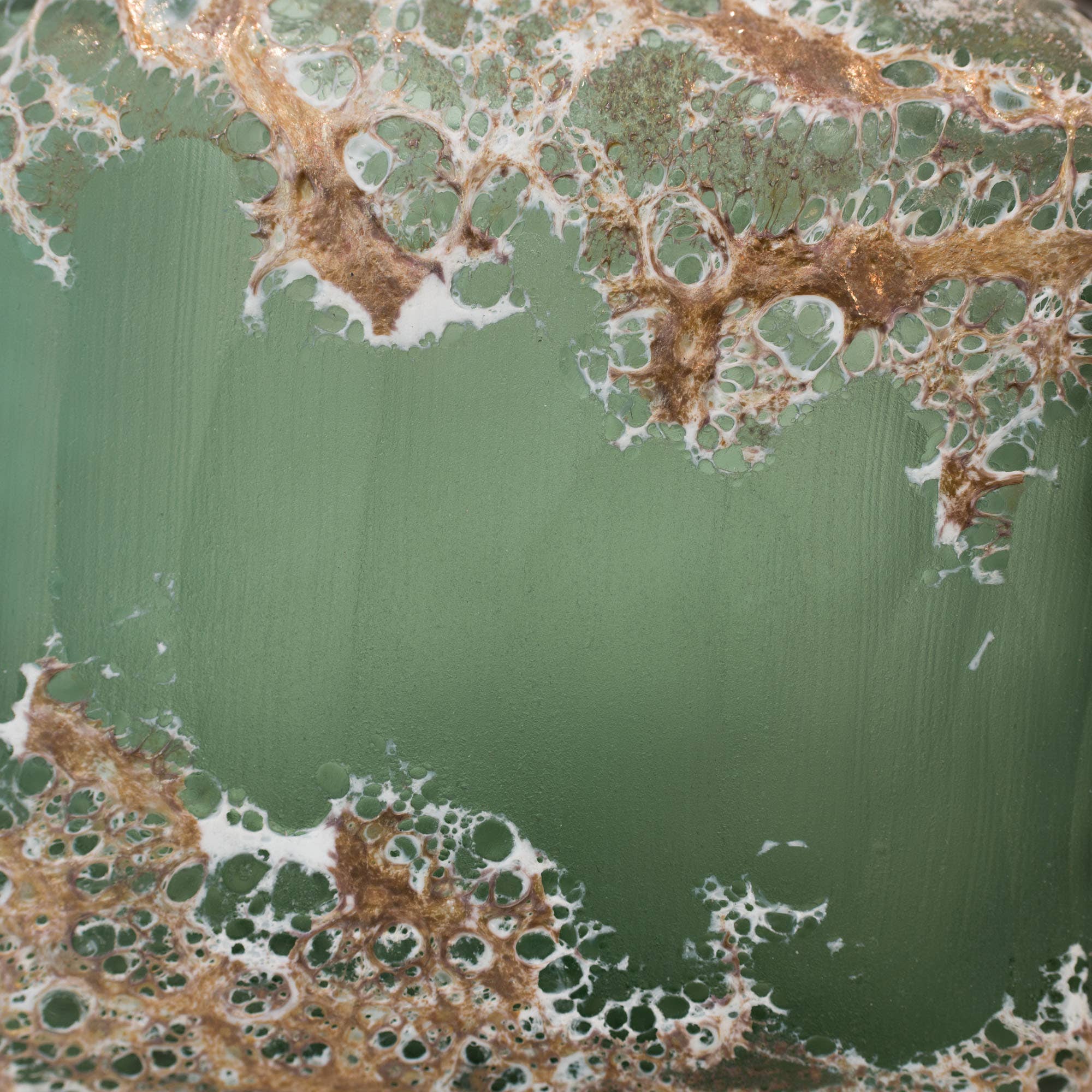 Green ceramic vase with marbled pattern on a green background