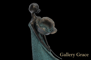 Bronze sculpture of a figure holding a flower on a white background