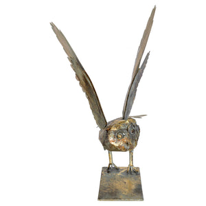 Metallic owl sculpture with open wings on a white background