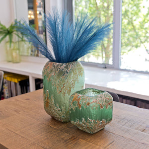 Green ceramic vase with marbled pattern on a green background